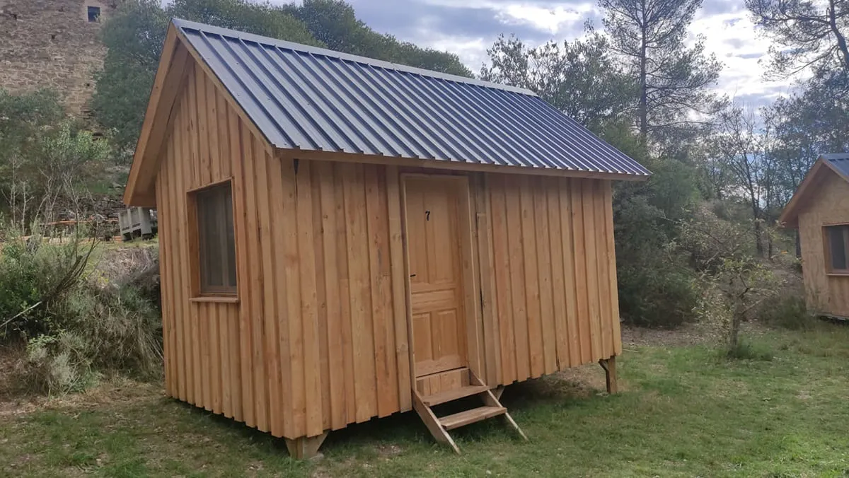 Tejado de cabaña de madera con chapa trapezoidal negra