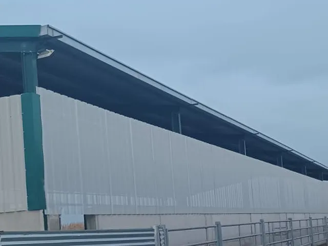 Nave ganadera con cerramiento de chapa trapezoidal perforada para ventilación natural